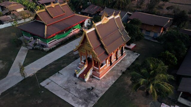 Traditional beautifully decorated Laos architecture, arched roof on old temple pagoda. Drone aerial view.