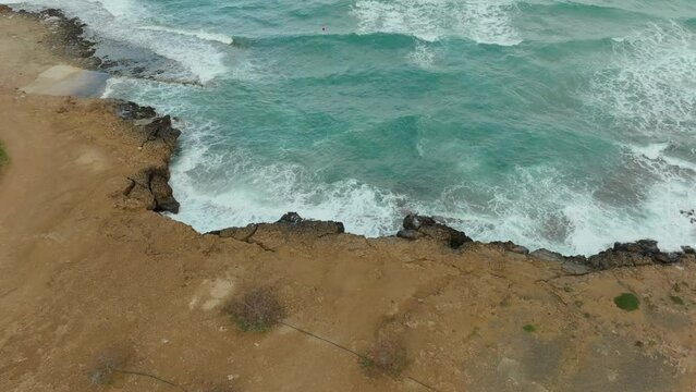 Foamy Crashing Waves Against Craggy Cliffs In Cyprus, Middle East. Slow Motion Shot
