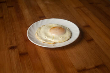 Sunny side up egg fry omelette poached served in plate isolated on wooden table top view of indian breakfast food
