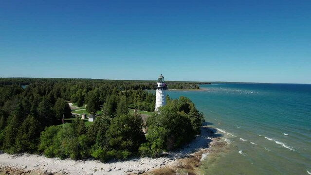 Drone aerial shot pulling back from a light house on the shores of door county, WI
