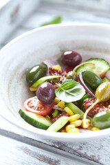 Simple Salad with Green and Kalamata Olives, Cucumber, Cherry and marinated Tomatoes, Capers and Jalapeno Pepper. Bright wooden background. T