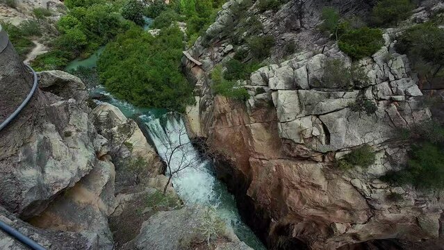 Slowmotion tilt view of water falling down in the Caminito del Rey in Spain.