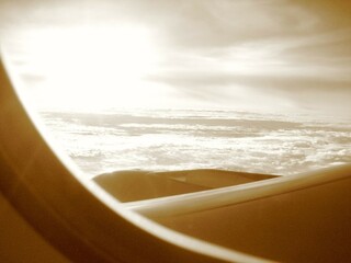 Clouds and sky with sunrise as seen through window of an aircraft