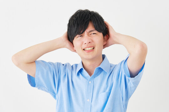頭を抱える若い男性　白背景