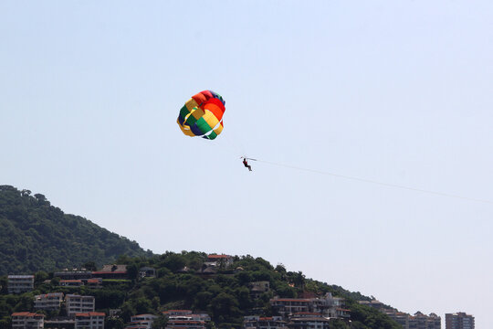 Parasailing, Parascending or Parakiting is an aquatic activity where a person attached to a parachute is towed by a boat at speed, causing them to rise above the water