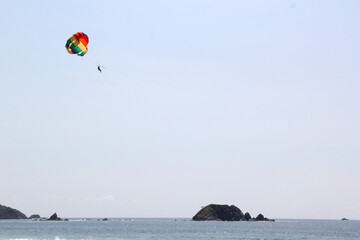 Parasailing, Parascending or Parakiting is an aquatic activity where a person attached to a parachute is towed by a boat at speed, causing them to rise above the water