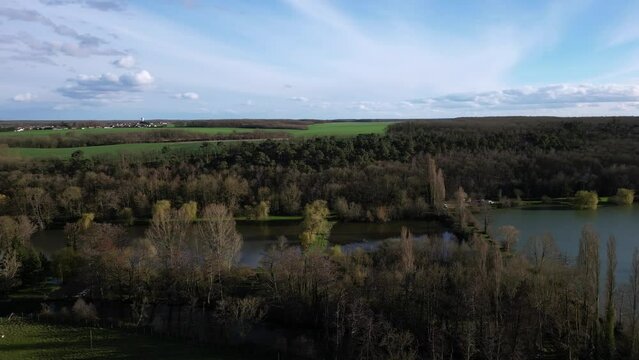 Dampiere sur Avre pond and surrounding rural landscape, France. Aerial drone panoramic view and sky for copy space
