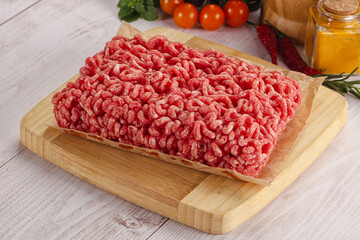 Raw minced beef meat over board