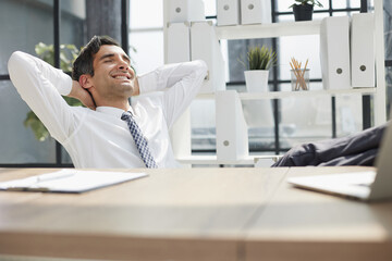 Relax, stretch and happy business man at the table in planning, work and office or work purposes.