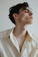 A photo of a minimal modern fashion shoot with young Spanish men, featuring an oversized beige shirt and large gold earrings, in muted earthy colors, with creative editorial photography.