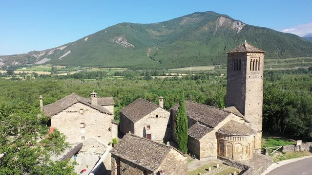 Aerial view of bell tower and apse of the Mozarab Pre-Romanesque or Romanesque Church of San Pedro de Larrede in the Serrablo Region. Aragon. Spain. High quality 4k footage