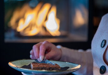 A lady in a atmospheric restaurant with a dessert in her hand.