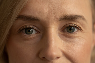 A close-up shot captures the contemplative expression of a mature woman. Her gaze is fixed...