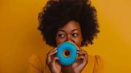 multicultural female holding delicious sweet donut on yellow studio background