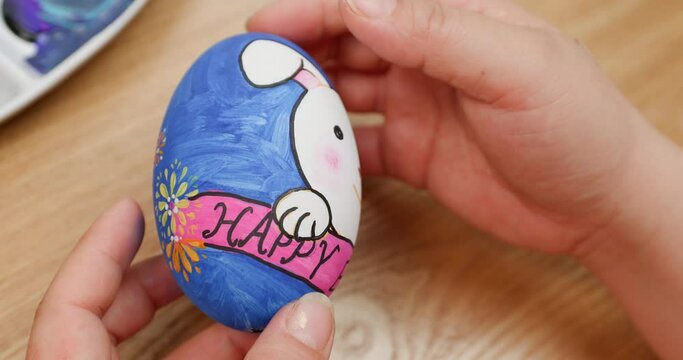 Happy Easter holiday.Close-up shot of a Mother's hands painting easter eggs,Coloring eggs top view,family traditions. easter bunny