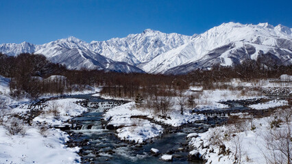 冬の白馬村　冠雪した北アルプス、五竜岳と松川