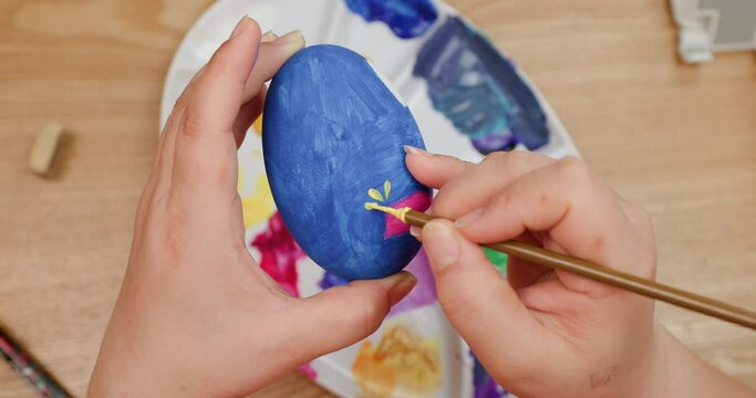 Happy Easter holiday.Close-up shot of a Mother's hands painting easter eggs,Coloring eggs top view,family traditions. easter bunny