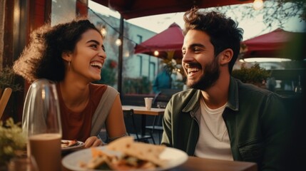 A man and a woman sitting at a table with a plate of food. Suitable for food blogs and restaurant promotions - obrazy, fototapety, plakaty