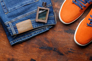 Men's Clothing on Wooden Background: Jeans, Sneakers, Perfume - 755403066