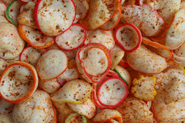 Background texture of kerupuk seblak, is colorful round crackers with spicy chili powder topping
