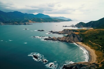 A stunning aerial view of a beach with mountains in the background. Perfect for travel or nature concepts