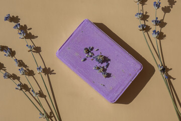 Lavender soap on beige background with copy space for your text. Advertisement template mock up. Skincare homemade natural cosmetic concept. Organic dry lavender flower