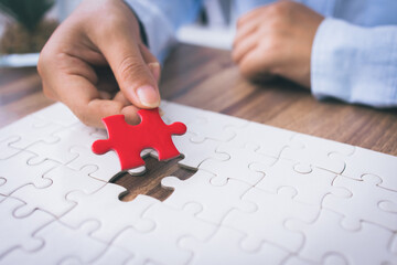 Closeup hand of woman connecting jigsaw puzzle. Business solutions, success and strategy concept.