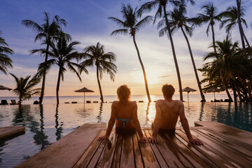 holidays, couple relaxing near swimming pool in luxury hotel resort at sunset on tropical island, honeymoon vacation travel - obrazy, fototapety, plakaty