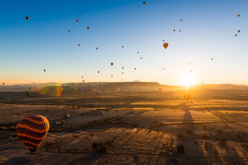 Colorful hot air balloons over the hills at sunrise in Cappadocia, Turkey.
