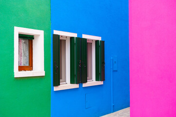 Blue, pink and green painted facades of the houses. Colorful architecture in Burano, Italy.