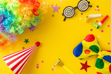 April Fool's prank top view setup featuring whimsical glasses, vibrant clown wig, playful bow tie, festive hat, blowers, colorful confetti scattered on sunny yellow backdrop, space for text included