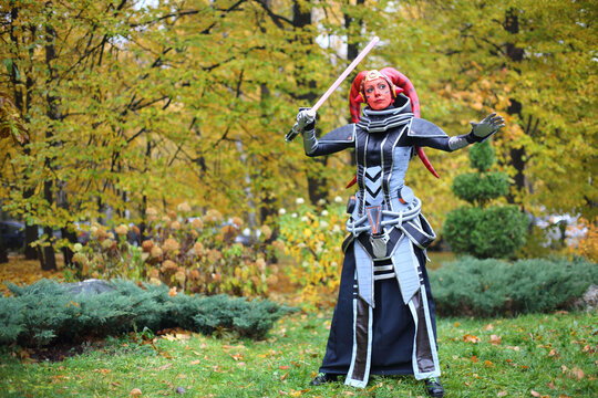  Cosplayer Darth Talon with red head in a fantastic dress 
