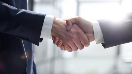 Businessmen shake hands with each other in close-up in the office