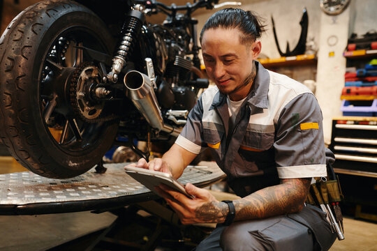 Smiling repairman detecting problem with application on tablet computer - Powered by Adobe