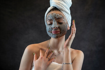 Female face with gray bubble mask as anti aging treatment for perfect skin isolated on black