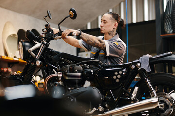 Fototapeta na wymiar Repairman setting motorcycle handlebar when working in garage