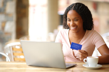 Black online buyer paying online in a restaurant - 755437811