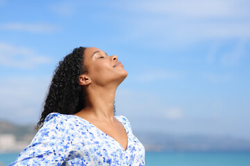 Black woman breathing fresh air on the beach - 755437839