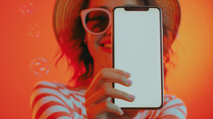 front view blur Beautiful woman face with reflect sun glass stretch arm to the front ponting and showing smartphone mockup blank white screen and smiling - obrazy, fototapety, plakaty