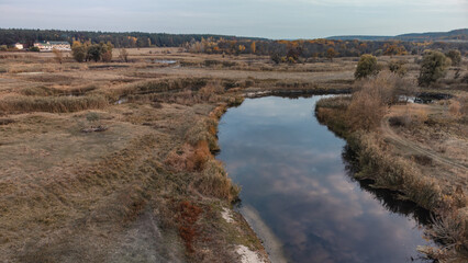 Aerial panorama of river turn in autumn with reeds and golden trees countryside