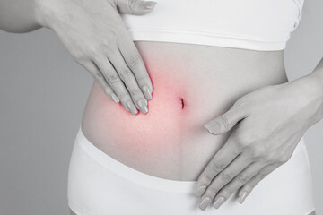 Stomach pain, and diarrhea. Woman's Hand holding the injured area of abdomen. Concept of women's...