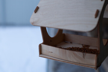 Close-up of a wooden feeder with blurred background