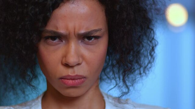 A dark-skinned young woman is angry, frowning, angry, a young woman is angry and looks at the camera, a young mestizo woman looks furiously into the frame, scared and dangerous.