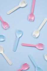 Set of kid forks lying on blue background.