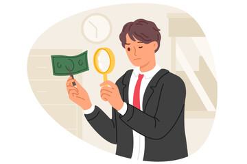 Expert examines counterfeit dollar money by using magnifying glass to look for inaccuracies in fake banknotes. Fake money printed by criminal in hands of inspector investigating crime