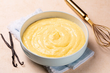 Vanilla pastry cream or custard crea in a light blue bowl. Made with milk, egg yolks and sugar, thickened with corn starch.