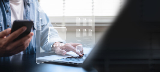 Document management system concept, Businessman using a laptop computer and smartphone at the...