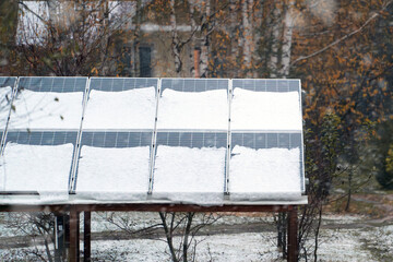 Solar panels are covered with snow in winter. Photovoltaic electricity installation during the...