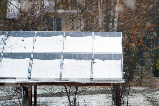Solar panels are covered with snow in winter. Photovoltaic electricity installation during the winter season. Alternative energy home production in cold weather.