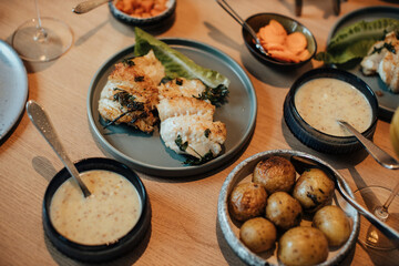 fully served dinner table with grilled fish fillets